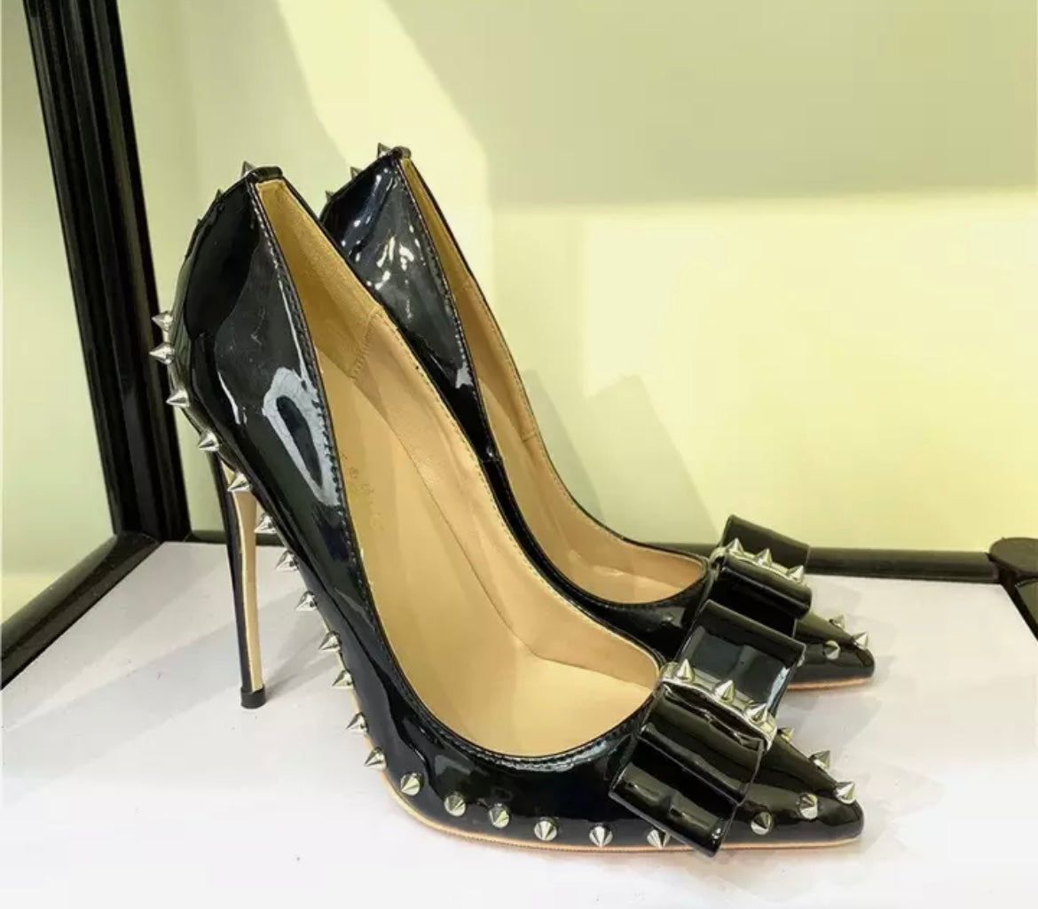 Black  high heeled court shoe with spikes and a bow